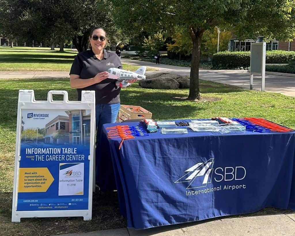 Woman holding an inflatable plane with a merchandise table